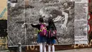 Dua anak sekolah melihat foto jurnalistik karya Sara Blesener, Kolombia (1/11). Karya ini diprakarsai oleh Dysturb, sebuah komunitas jurnalis foto yang berkeinginan membuat informasi visual secara bebas diakses oleh khalayak luas. (AFP PHOTO/luis acosta)
