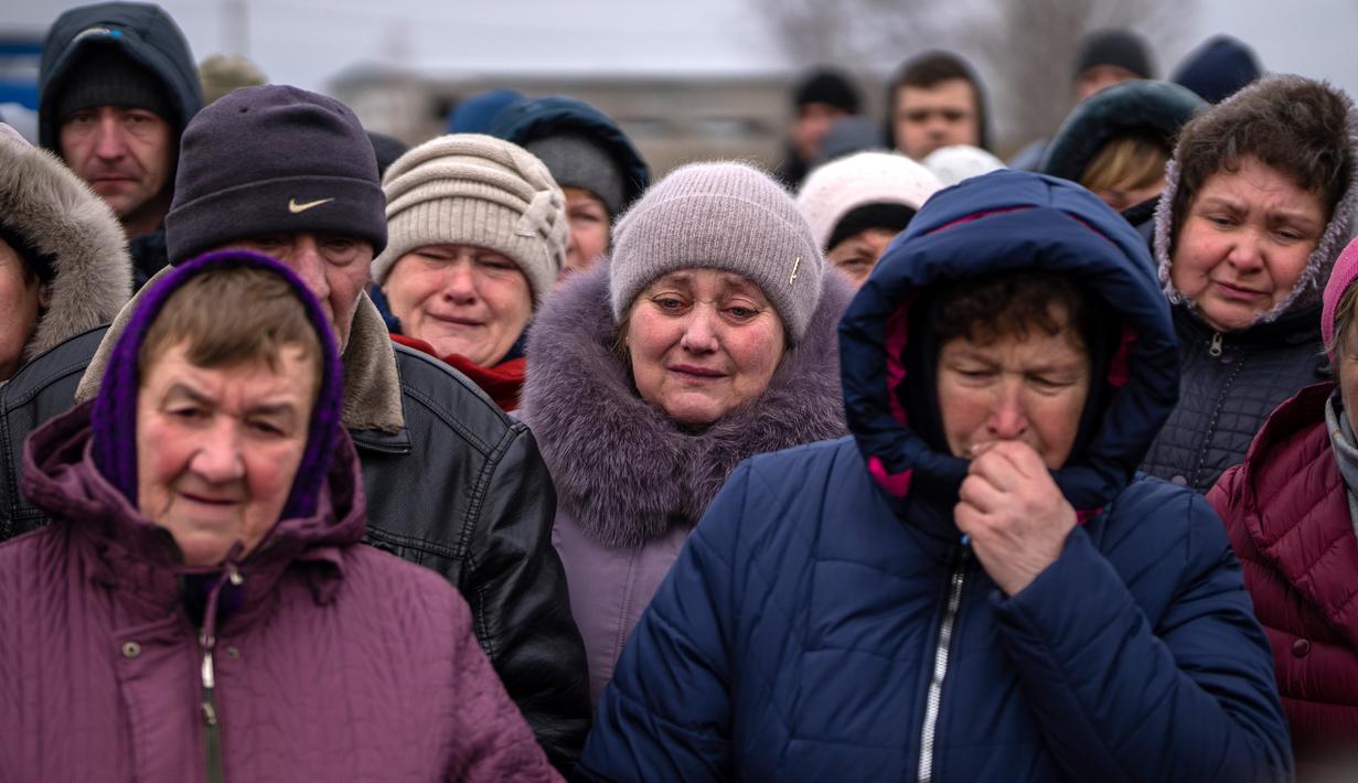 Para pelayat bereaksi di samping jenazah Oleksandr Maksymenko (38) saat pemakamannya di kampung halamannya di Kniazhychi, sebelah timur Kyiv, Ukraina, 13 Februari 2023. Oleksandr Maksymenko, seorang warga sipil yang menjadi sukarelawan di angkatan bersenjata Ukraina, tewas dalam pertempuran di daerah Bakhmut. (AP Photo/Emilio Morenatti)
