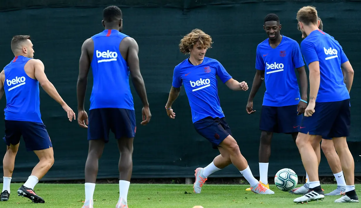 Penyerang baru Barcelona, Antoine Griezmann tersenyum ketika mengikuti latihan di Joan Gamper, Barcelona (15/7/2019). Griezmann dibeli Barcelona dengan mahar 120 juta euro atau senilai Rp 1,8 triliun dari Atletico Madrid. (AFP Photo/Lluis Gene)