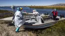 Petugas kesehatan tiba di pulau Uros untuk menyuntik warga dengan vaksin COVID-19 Sinopharm, di danau Titicaca di Puno, Peru, pada 7 Juli 2021. Peru memulai vaksinasi COVID-19 untuk ratusan penduduk asli yang tinggal di pulau terapung Uros, di Danau Titicaca. (Carlos MAMANI / AFP)