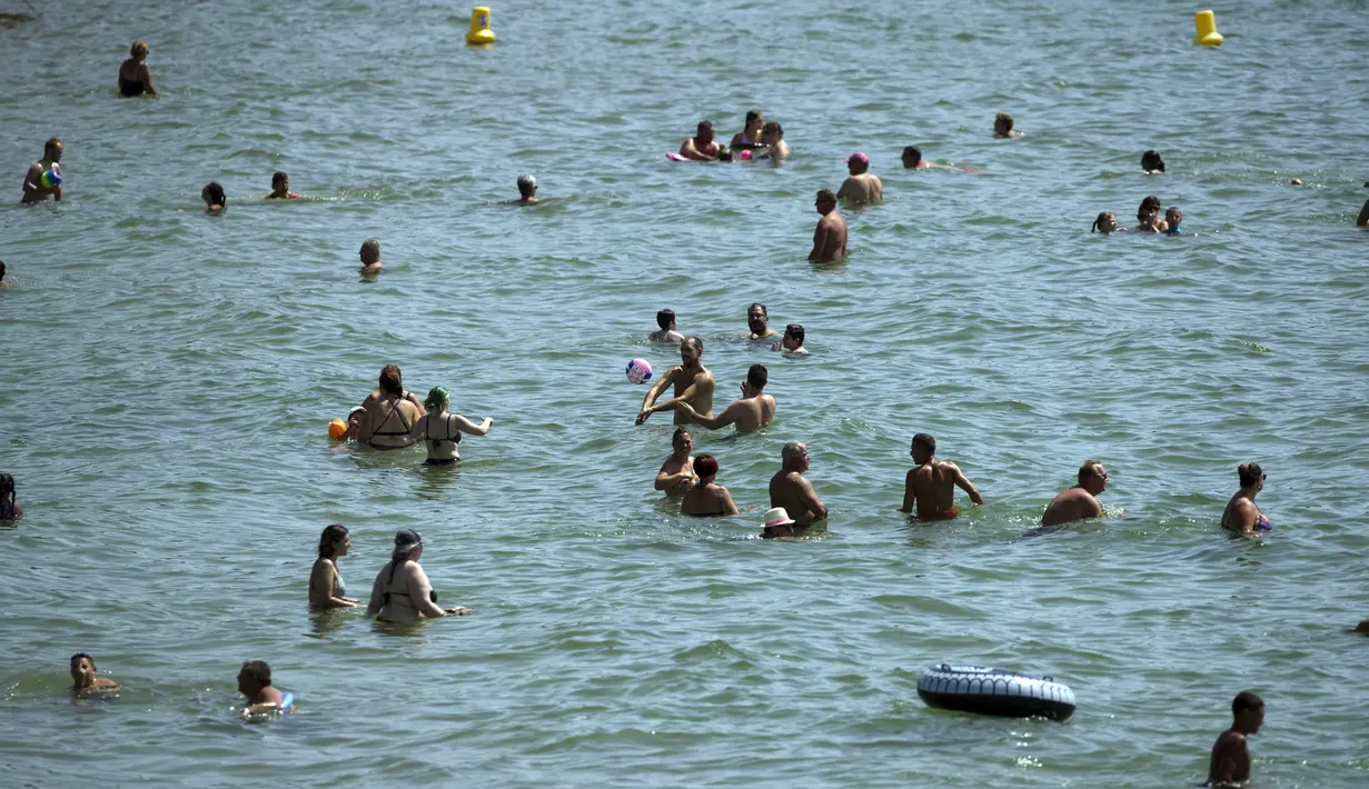 Para pengunjung menikmati hari yang panas di bawah sinar matahari pantai Bormes-les-Mimosas, Prancis, Selasa (11/8/2020). Cuaca panas diperkirakan akan berlangsung selama beberapa hari di seluruh negeri. (AP Photo/Daniel Cole)