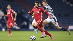 Penyerang Liverpool, Mohamed Salah berebut bola dengan bek West Bromwich Albion, Conor Townsend dalam laga lanjutan Liga Inggris di Stadion The Hawthorns, Minggu (16/5/2021). Alisson Becker menjadi pahlawan Liverpool saat mengalahkan West Bromwich Albion 2-1. (Laurence Griffiths/Pool via AP)