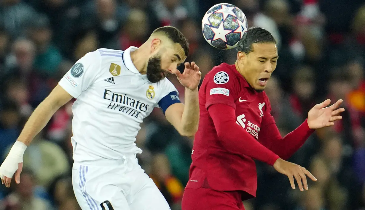 Pemain Real Madrid Karim Benzema (kiri) melompat untuk berebut bola udara dengan pemain Liverpool Virgil van Dijk pada pertandingan sepak bola leg pertama babak 16 besar Liga Champions di Stadion Anfield, Liverpool, Inggris, 21 Februari 2023. Real Madrid mengalahkan Liverpool dengan skor 5-2. (AP Photo/Jon Super)
