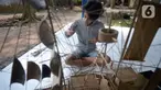 Perajin menyelesaikan pembuatan miniatur kapal pinisi yang terbuat dari limbah bambu di Pondok Benda, Pamulang, Tangerang Selatan, Senin (09/11/2020). Kerajinan berbahan bambu bekas yang dijual dengan harga berkisar Rp.50 ribu hingga Rp.250 ribu tergantung ukurannya. (merdeka.com/Dwi Narwoko)
