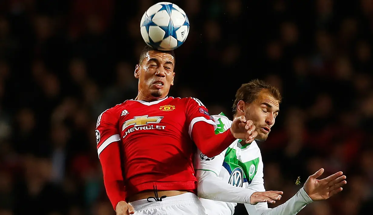 Bek MU, Chris Smalling berebut bola udara dengan penyerang Wolfsburg, Bas Dost pada laga Liga Champions di Stadion Old Trafford, Inggris, Kamis (1/10/2015). MU menang atas Wolfsburg dengan skor 2-1. (Reuters/Lee Smith)