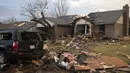 Puing-puing berserakan di luar sebuah rumah yang rusak parah akibat tornado di Oxford Drive di Round Rock, Texas, Senin (21/3/2022). (Jay Janner/Austin American-Statesman via AP)