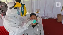 Warga yang hendak berlibur melakukan rapid test antigen yang disediakan oleh Dinas Kesehatan dan Petugas Gabungan dari unsur TNI, Polri dan Satpol PP Provinsi Jawa Barat di Rest Area KM 57, Tol Jakarta-Cikampek, Karawang, Jawa Barat, Kamis (24/12/2020). (Liputan6.com/Herman Zakharia)