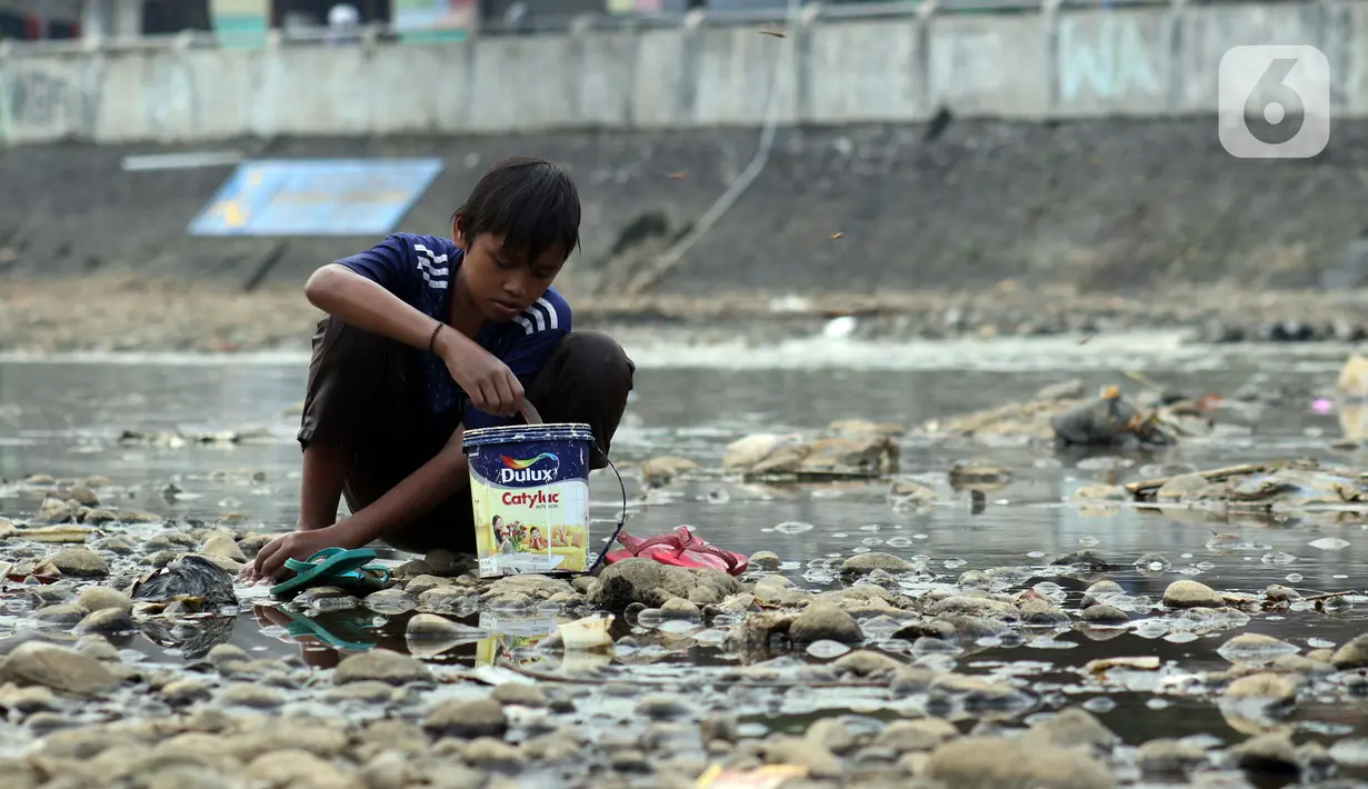 Seorang anak mencuci pakaian di area Bendung Katulampa, Kota Bogor, Jawa Barat, Senin (3/8/2020). Debit air sungai Ciliwung di Bendung Katulampa yang mengalami penyusutan sejak satu bulan terakhir dimanfaatkan anak-anak untuk bermain air dan layangan. (Liputan6.com/Helmi Fithriansyah)