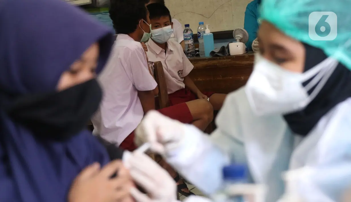 Sejumlah siswa mengikuti vaksinasi COVID-19 untuk murid sekolah dasar di SDN Panunggangan 5, Pinang, Kota Tangerang, Selasa (19/10/2021).  Pelaksanaan vaksinasi untuk pelajar usia 12 tahun ini dilakukan dalam rangka persiapan pelaksanaan pembelajaran tatap muka (PTM). (Liputan6.com/Angga Yuniar)