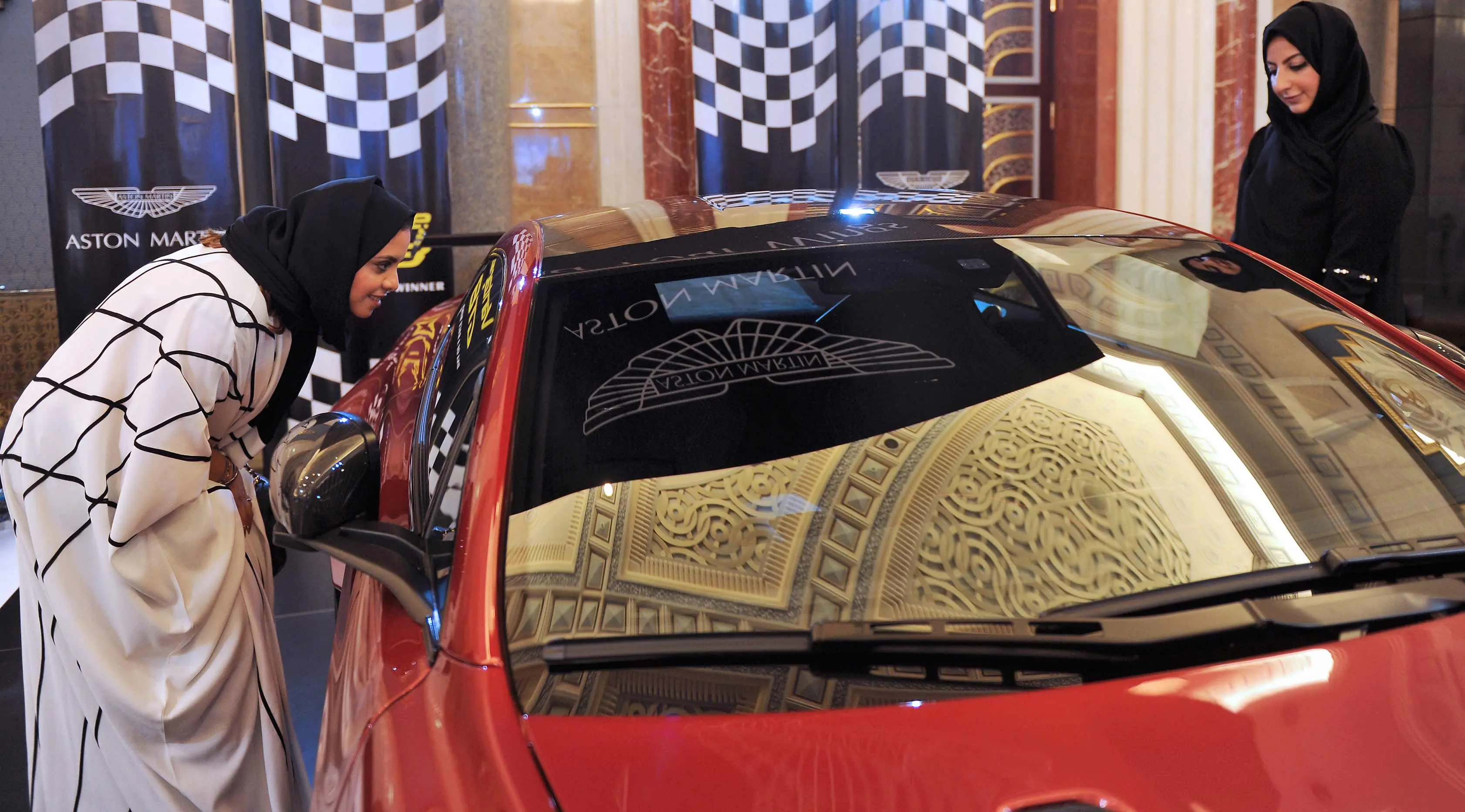 Dua wanita Saudi melihat sebuah mobil di sebuah pameran mobil di resor Jeddah Laut Merah Jeddah (5/10). Pada bulan September 2017 Kerajaan Arab Saudi mengeluarkan dekrit yang memperbolehkan wanita untuk mengendarai mobil. (AFP Photo/Amer Hilabi)