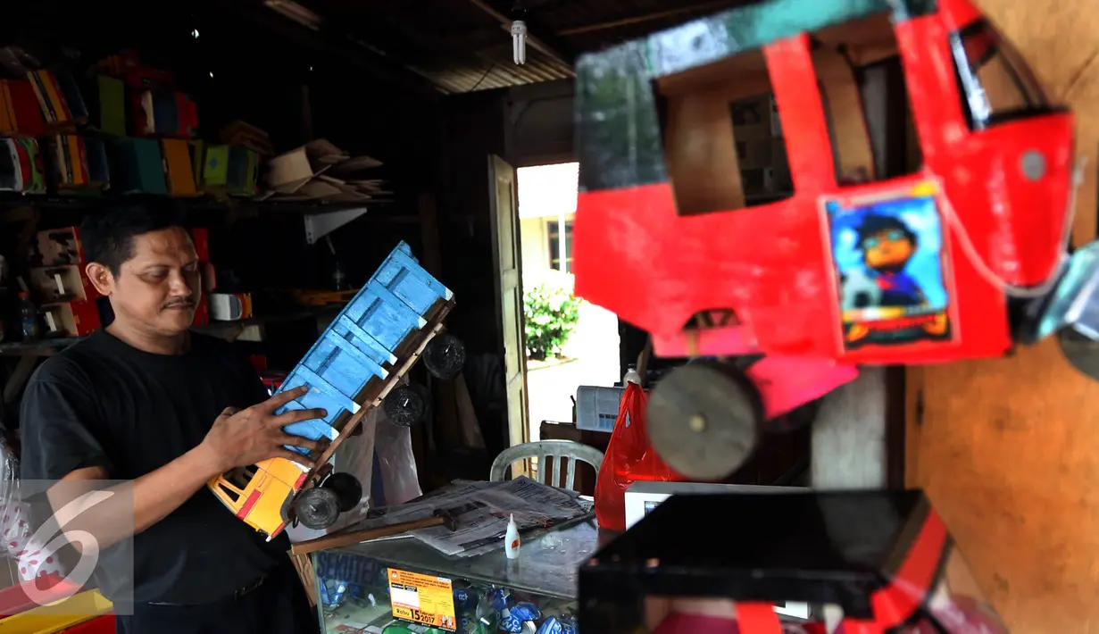 Pedagang mainan kayu mengecek barang dagangannya di kawasan Kalibata, Jakarta, Selasa (18/10). Gempuran mainan-mainan modern tidak membuat pengusaha mainan kayu tradisional patah arang. (Liputan6.com/Johan Tallo)