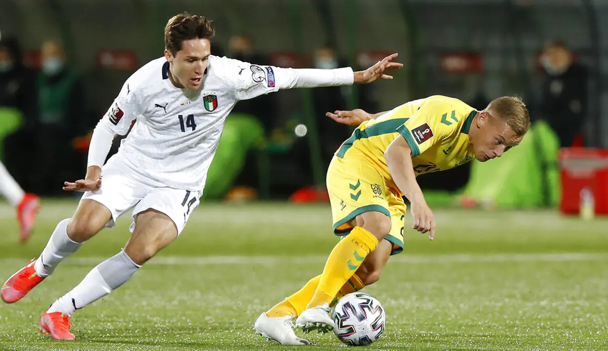 Pemain Italia Federico Chiesa (kiri) memperebutkan bola dengan pemain Lithuania Domantas Simkus pada pertandingan Grup C kualifikasi Piala Dunia 2022 di Stadion LFF, Vilnius, Lithuania, Rabu (31/3/2021). Italia menang 2-0. (AP Photo/Mindaugas Kulbis)