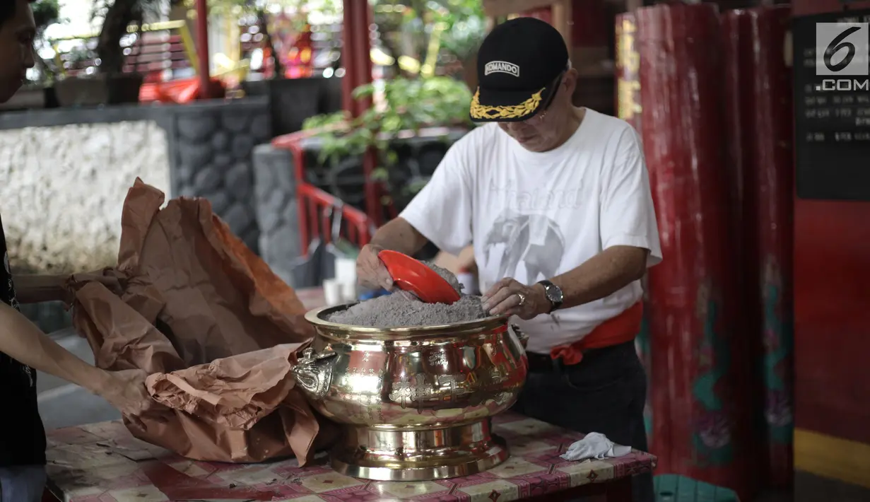 Seorang warga menyiapkan perlengkapan ibadah di Vihara Amurva Bhumi, Jakarta, Kamis (8/2). Dalam kepercayaan Tionghoa, memandikan patung ini dilakukan sehari sebelum dewa Tepekong naik ke langit untuk melaporkan keadaan bumi. (Liputan6.com/Arya Manggala)