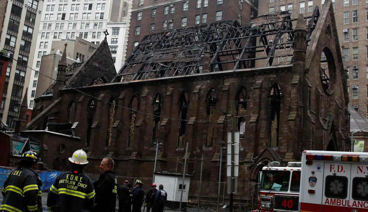 Petugas pemadam kebakaran New York berkumpul di depan Gereja Katedral Ortodoks Serbia dari Saint Sava di Manhattan, pasca kebakaran yang terjadi pada Minggu, 1 Mei 2016, beberapa saat setelah umat merayakan Paskah, Senin (2/5). (REUTERS/Brendan McDermid)