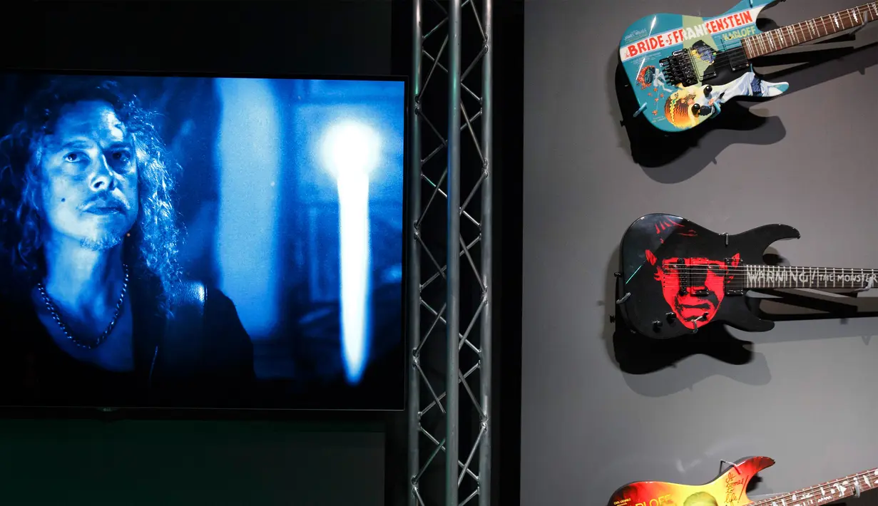 Wajah Hammet yang berdampingan dengan gitar koleksinya di pameran Museum Peabody Essex, Massachusetts, Rabu (9/8). Kebanyakan poster film milik Hammet ini merupakan film yang diproduksi tahun 1930an sampai 1970an. (AP/Michael Dwyer)