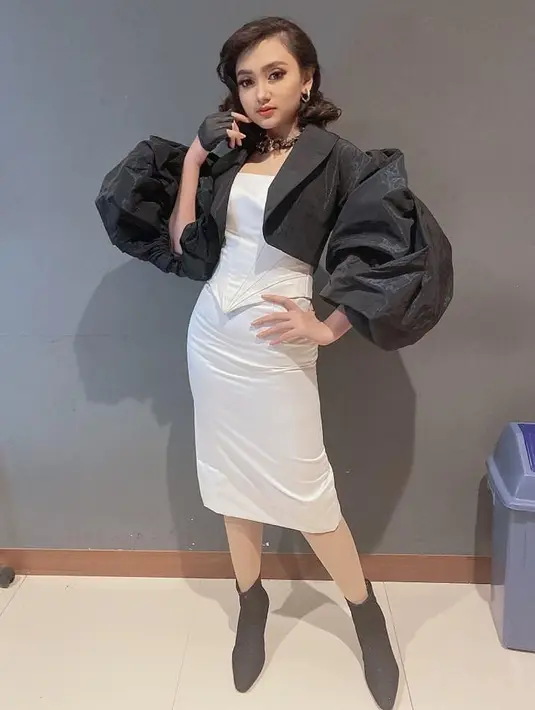 Jihan Audy juga mengandalkan hitam putih sebagai warna outfit manggungnya. Blazer hitam berlengan balon, dipadukan dengan dress putih dan sepatu hitam, membuatnya nampak elegan saat di atas panggung. (Liputan6.com/IG/@jihanaudy123_real).
