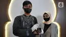 Pasangan Artahabayu dan Salwa menunjukkan mas kawin usai melangsungkan pernikahan di KUA Kecamatan Meteng, Jakarta, Selasa (22/2/2022). Sejumlah pasangan sengaja melangsungkan pernikahan pada hari ini yang memiliki tanggal, bulan, dan tahun unik yakni 22-02-2022. (Liputan6.com/Herman Zakharia)