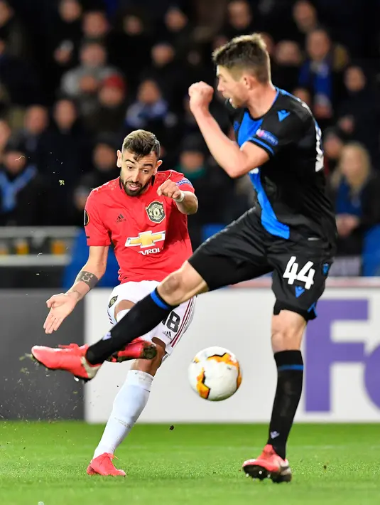 Gelandang Manchester United, Bruno Fernandes berebut bola dengan pemain Club Brugge, Brandon Mechele dalam leg pertama babak 32 besar Liga Europa di Jan Breydelstadion, Kamis (20/2/2020). Manchester United gagal meraih hasil maksimal usai ditahan imbang Club Brugge 1-1. (JOHN THYS / AFP)
