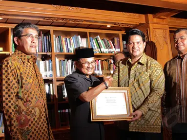 Presiden ke-3 RI, BJ Habibie (kedua dari kiri) menerima penghargaan dari KPU Pusat di Jakarta, Senin (29/12). (Liputan6.com/Faizal Fanani)