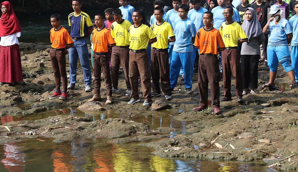 Komunitas Ciliwung bersama pelajar dan warga mengikuti upacara bendera di Sungai Ciliwung, Depok, Jumat (17/8). Upacara HUT ke-73 RI tersebut bertujuan mengedukasi masyarakat untuk menjaga kelestarian Sungai Ciliwung. (Liputan6.com/Immanuel Antonius)