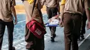 Sejumlah siswa menggotong temannya saat simulasi bencana di SMA Negeri 78 Jakarta Barat, Rabu (23/1). Kegiatan itu untuk pengenalan kepada siswa-siswi dengan program siaga bencana berupa simulasi evakuasi gempa dan tsunami. (Liputan6.com/Faizal Fanani)