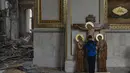Seorang anak laki-laki mencium patung Yesus saat membantu membersihkan Katedral Transfigurasi Odesa setelah gereja rusak berat akibat serangan rudal Rusia di Odesa, Ukraina, Minggu, 23 Juli 2023. (AP Photo/Jae C. Hong)