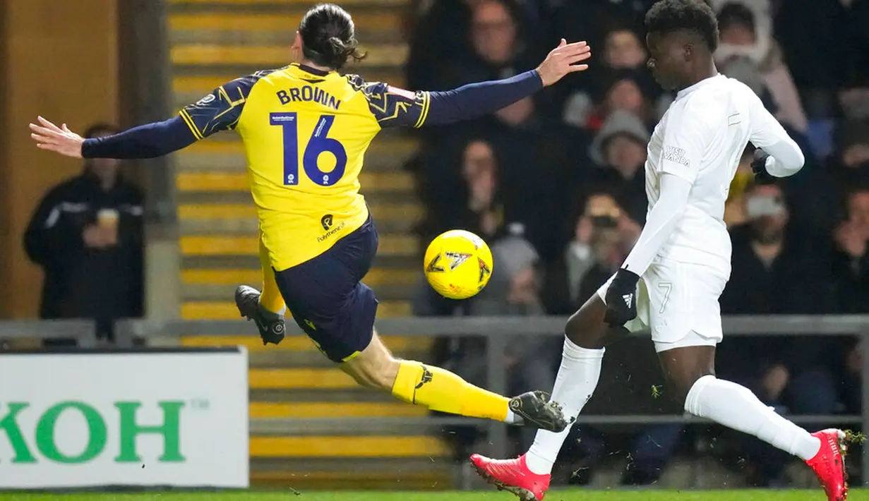Pemain Arsenal Bukayo Saka (kanan) berebut bola dengan pemain Oxford United Ciaron Brown (kiri) pada pertandingan sepak bola Piala FA di Stadion Kassam, Oxford, Inggris, 9 Januari 2023. Arsenal menang 3-0. (AP Photo/Frank Augstein)