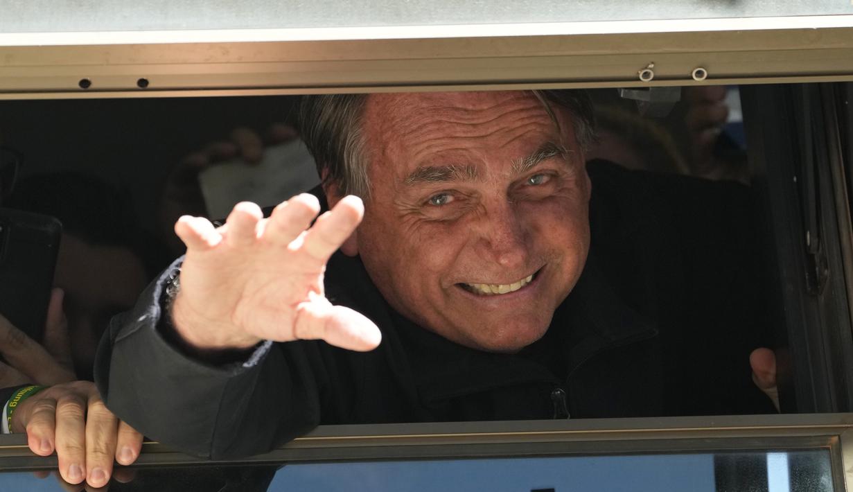 Mantan Presiden Brasil Jair Bolsonaro melambai kepada pendukungnya di markas Partai Liberal di Brasilia, Brasil, Kamis (30/3/2023). (AP Photo/Eraldo Peres)