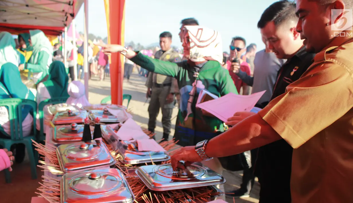 Ketua PKK Fory Naway, Ketua Panitia FPDL Hen Restu Tanjung bersama tim dari Rekor MURI menilai sebanyak 88.950 tusuk sate yang disajikan untuk memeriahkan Festival Pesona Danau Limboto, Gorontalo, Senin (24/9). (Liputan6.com/Arfandi Ibrahim)