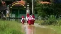 Banjir tak menghalangi siswa bersekolah karena ujian makin dekat.