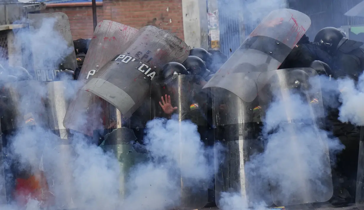 Kembang api yang dilemparkan pengunjuk rasa meledak di dekat formasi polisi saat terjadi bentrokan di dekat Kementerian Pendidikan di La Paz, Bolivia, Kamis, 13 April 2023. (AP Photo/Juan Karita)