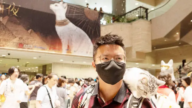 Salah satu pengunjung pameran yang turut mengajak kucing peliharaannya. (Foto. AFP)