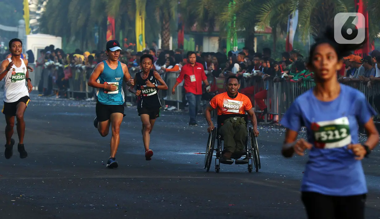 Peserta disabilitas memacu kursi roda balapnya di antara para peserta lomba lari bertajuk Lo Gue Run (LGR) 2020 di Kompleks Monas, Jakarta Pusat, Minggu (26/1/2020). Kodam Jayakarta menggelar lomba lari 'Loe Gue Run' yang merupakan puncak perayaan HUT ke-70 Kodam Jaya. (Liputan6.com/Johan Tallo)