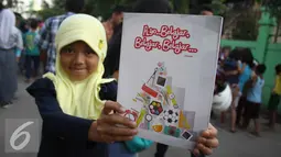 Seorang bocah memperlihatkan buku tulis yang ia peroleh dari Presiden Jokowi, Jakarta, Kamis (3/9/2015). Presiden Jokowi bersama Gubernur Ahok mengadakan blusukan dan membagikan semabko pada warga di kawasan Cilincing. (Liputan6.com/Gempur M Surya)