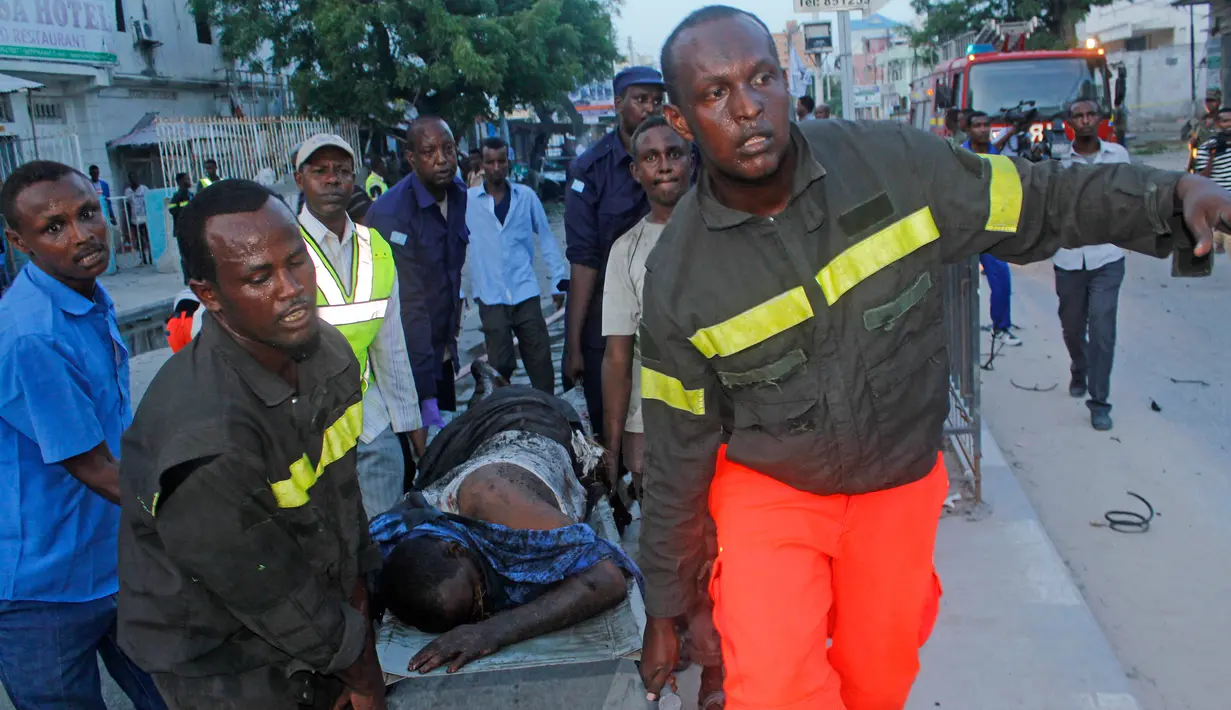 Petugas mengevakuasi korban serangan bom mobil di Mogadishu, Somalia (8/5). Setidaknya 6 orang tewas dan 10 orang lainnya terluka dalam serangan bom mobil tersebut. (AP Photo/Farah Abdi Warsameh)