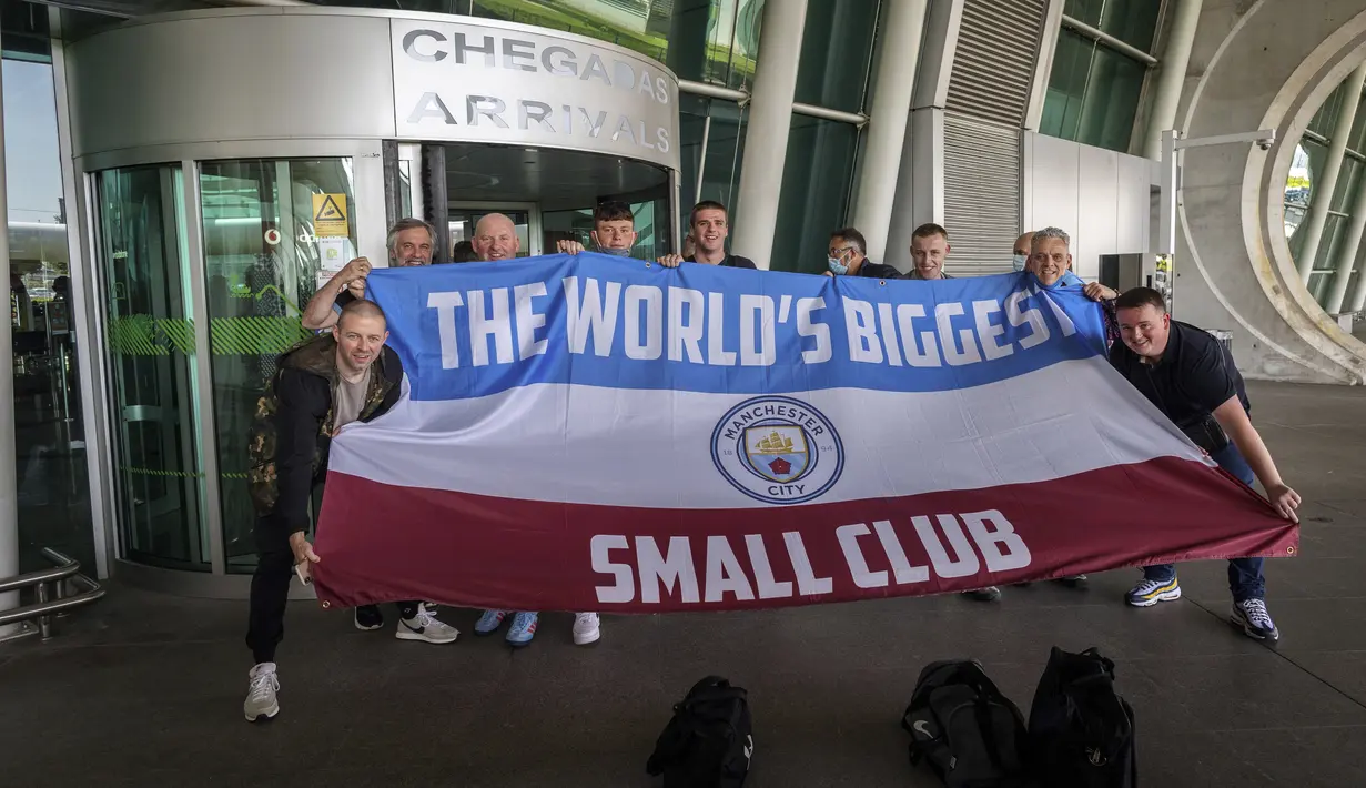 Suporter Manchester City berpose dengan bendera mereka di bandara di Porto, Portugal (28/5/2021). Klub Inggris Manchester City dan Chelsea akan memainkan final Liga Champions di stadion Dragao di Porto pada Sabtu malam atau Minggu (30/5/2021) dini hari. (AP Photo/Luis Vieira)