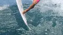 Peselancar asal Indonesia, Rio Waida melakukan manuver di atas ombak kejuaraan selancar dunia bertajuk "Corona Bali Protected" di Pantai Keramas, Gianyar, Bali, Minggu (19/5/2019). Event yang diberinama Corona Bali ProTected digelar pada 13 Mei hingga 25 Mei 2019. (SONNY TUMBELAKA / AFP)