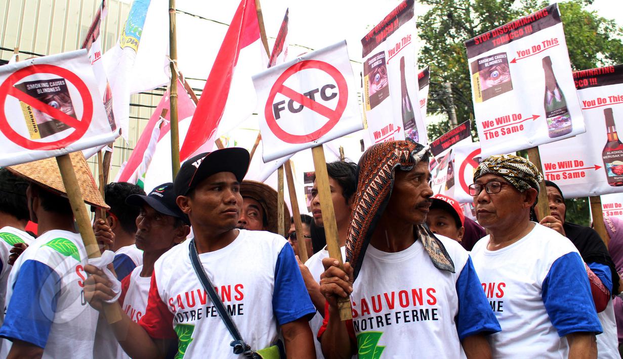 Ratusan petani yang tergabung dalam APTI membawa poster saat berunjukrasa di depan Kedutaan Besar Prancis, Jakarta, Selasa (9/6/2015). Aksi dilakukan terkait kebijakan Prancis menerapkan kemasan rokok polos (plain packaging).  (Liputan6.com/Johan Tallo)