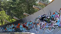 Freestyler sepeda saat asyik memacu sepedanya di jalur luge di Bosnia-Herzegovina , Jumat (8/8/2015). Kawasan ini tidak dirawat dan dibiarkan runtuh akibat digunakan markas tentara Bosnia dan Herzegovina pada perang 1991. (Reuters/Dado Ruvic)