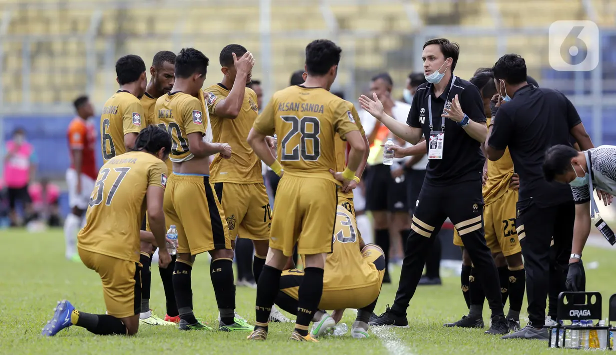 Pelatih Bhayangkara Solo FC Paul Christopher Munster memberikan instruksi kepada pemainnya saat water break melawan Borneo FC Samarinda dalam pertandingan babak penyisihan Piala Menpora 2021 di Stadion Kanjuruhan, Malang, Jawa Timur, Senin (22/3/2021). (Bola.com/Arief Bagus)
