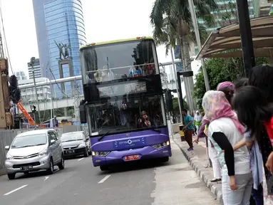 Sejumlah calon penumpang menunggu bus tingkat wisata di kawasan Bundaran HI, Jakarta, Kamis (1/1/2015). (Liputan6.com/Faizal Fanani)