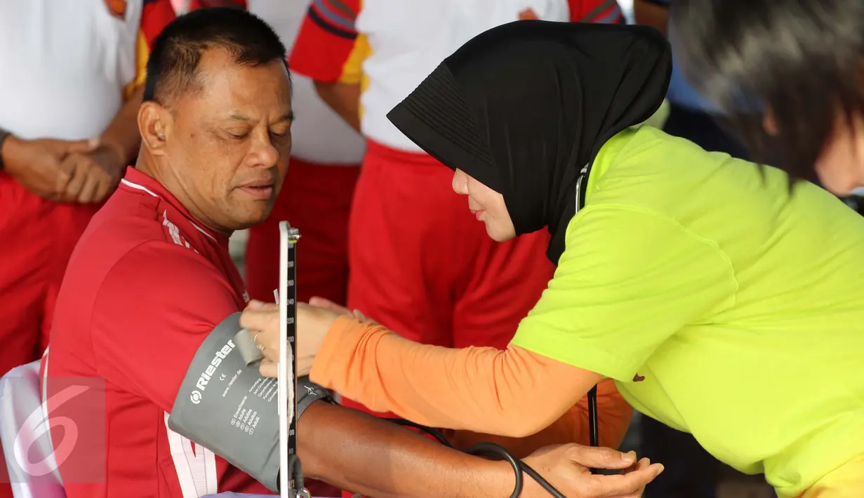 Panglima TNI Jenderal TNI Gatot Nurmantyo melakukan pemeriksaan tekanan darah sebelum mengikuti pertandingan eksebisi antara tim Eksekutif TNI vs PS Pemred di lapangan Mabes TNI Cilangkap, Jakarta, Jumat (21/10). (Liputan6.com/Risa Rahayu Kosasih)