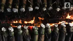 Pekerja membakar lemang atau beras ketan yang dimasukan ke bambu di kawasan Senen, Jakarta, Rabu (29/3/2023). (Liputan6.com/Herman Zakharia)
