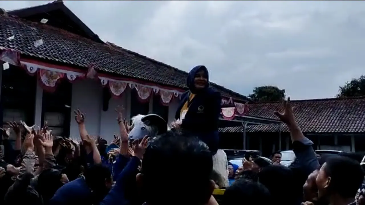 Ketua DPD Nasdem Kabupaten Garut, Jawa Barat sekaligus istri Bupati Garut Diah Kurniasari, terlihat saweran uang di halaman kantor KPUD Garut, (Liputan6.com/Jayadi Supriadin)