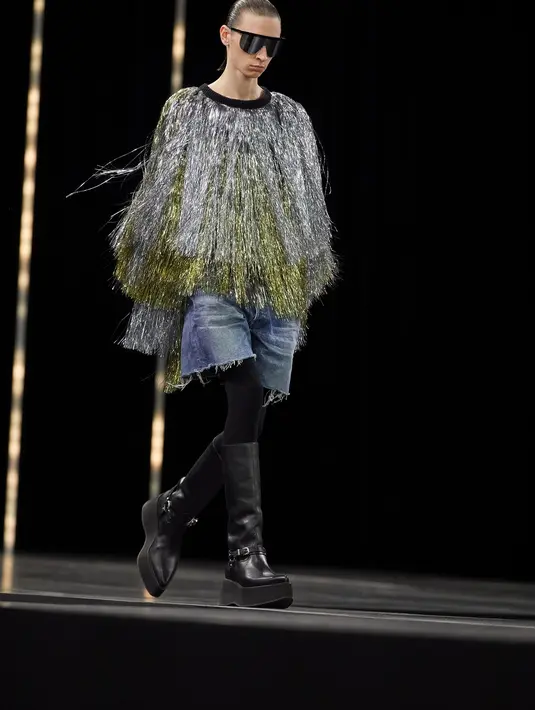 Yang menonjol dalam koleksi ini adalah fringed sweater berwarna silver dan gold yang dipadukan dengan celana jeans pendek dan sepatu boots. (Dok/Celine).