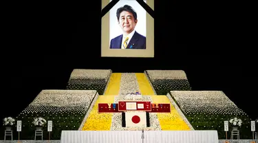 Potret mantan Perdana Menteri Jepang Shinzo Abe terlihat pada altar saat pemakaman kenegaraannya di Nippon Budokan, Tokyo, Jepang, 22 September 2022. Prosesi diawali dengan pemberian sambutan dari Wakil Ketua Panitia Pelayanan Pemakaman dan dilanjutkan dengan pengumandangan Lagu Kebangsaan Jepang. (Franck Robichon/Pool Photo via AP)