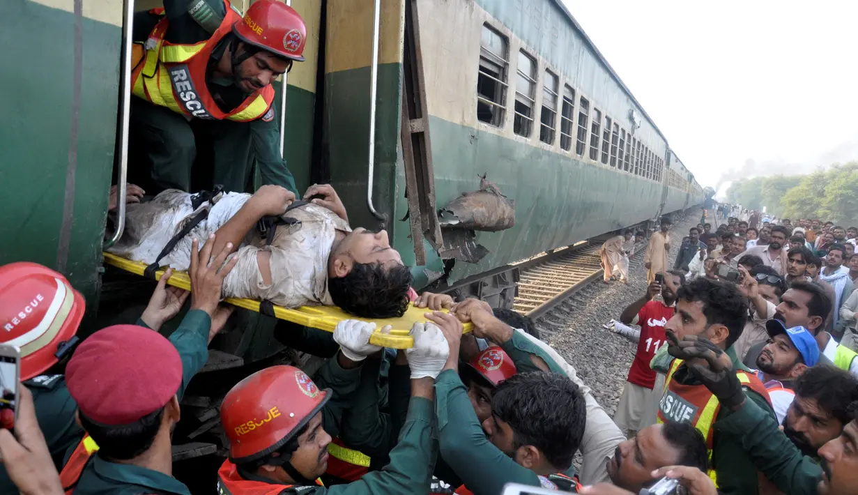 Petugas mengevakuasi salah satu korban tabrakan dua kereta api di Multan, Pakistan, Kamis (15/9). Kecelakaan itu terjadi ketika kereta penumpang menabrak kereta barang yang sedang berhenti karena ada seorang warga menyeberangi rel (REUTERS/Khalid Chaudry)