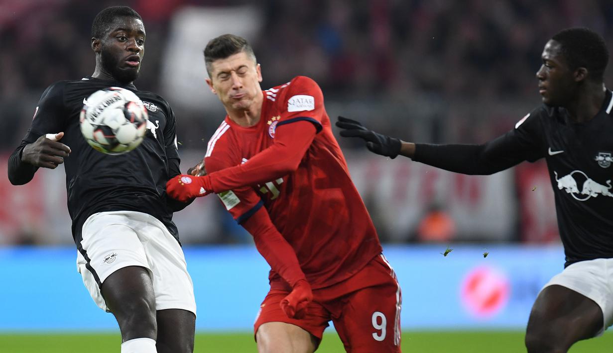 Striker Bayern Munich, Robert Lewandowski, berusaha melewati pemain RB Leipzig pada laga Bundesliga di Allianz Arena, Kamis (20/12). Bayern Munich menang 1-0 atas RB Leipzig. (AFP/Chirstof Stache)