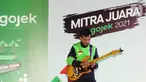Aksi driver ojol, Mas Bomenn main gitar pada acara Ngobrol Bareng Gojek sekaligus Apresiasi Mitra Juara Gojek di Jakarta, (5/11/2021). Apresiasi diberikan Gojek bagi mitra inspiratif yang terus menunjukkan optimisme, kerja keras, dan ketekunan. (Liputan6.com/Fery Pradolo)
