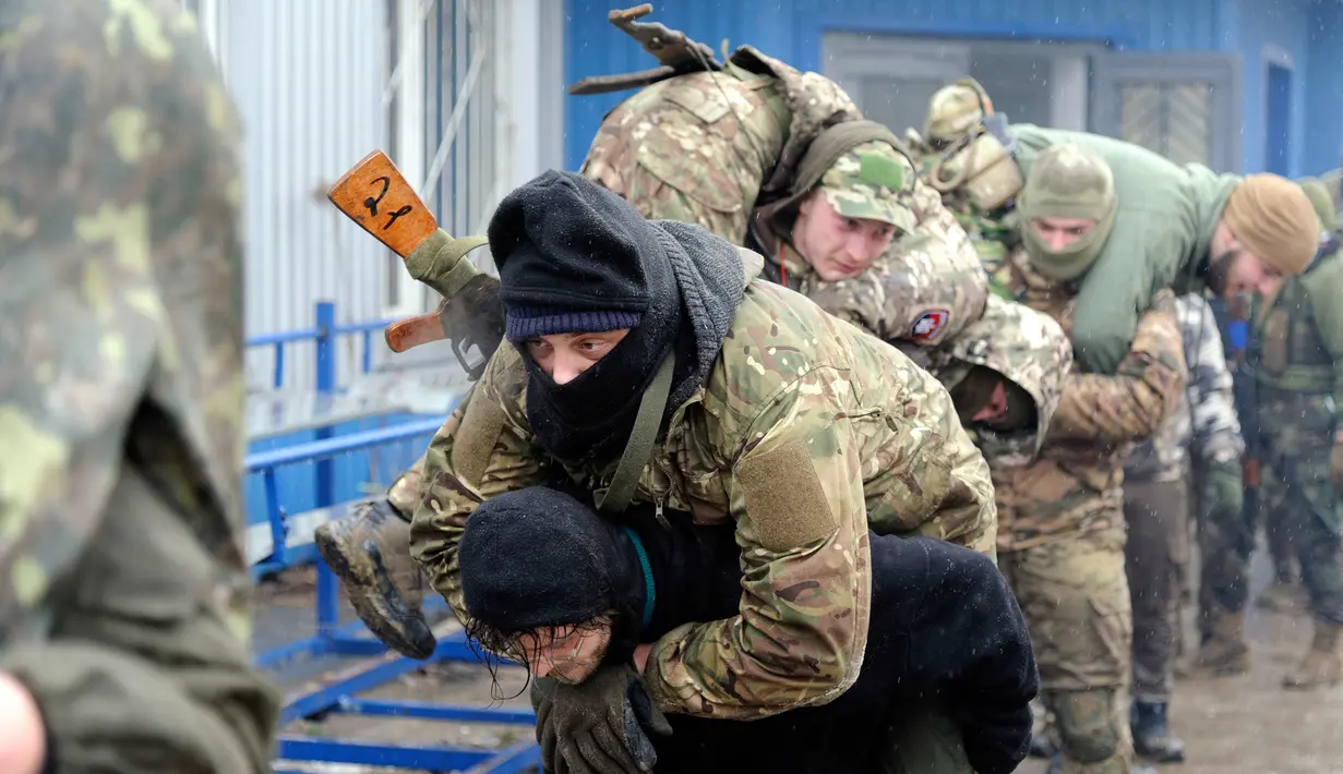 Warga sipil melakukan penyelamatan prajurit yang terluka saat mengikuti sesi pelatihan militer oleh Right Sector dekat Lviv, Ukraina, 24 Februari 2023. (AP Photo/Mykola Tys)